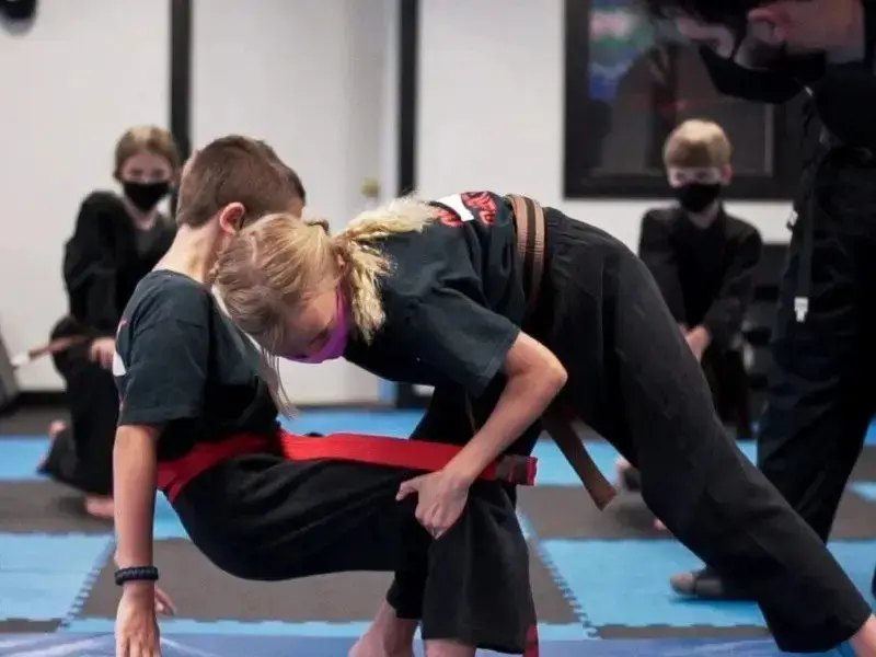 Teen martial arts students practice grappling drills to build teens self defense awareness.